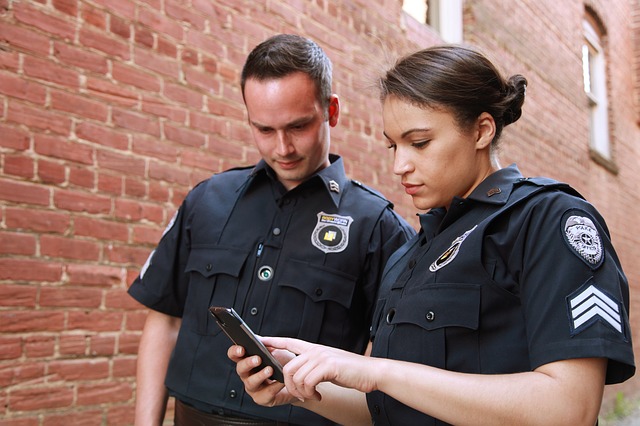 male, female, police officers looking at a cell phone