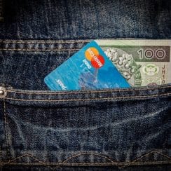 credit card and cash in a back pocket of a pair of jeans