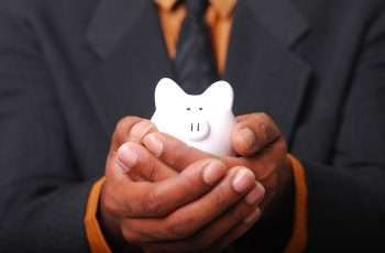 hands holding a piggy bank consistent with article on how to save money for college